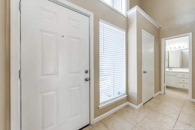 foyer entrance featuring sink and light tile patterned floors