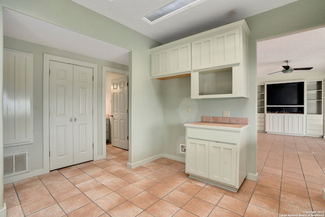 kitchen featuring light tile patterned flooring, white cabinetry, and ceiling fan