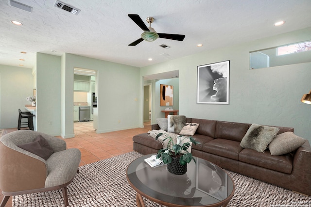 tiled living room featuring a textured ceiling and ceiling fan