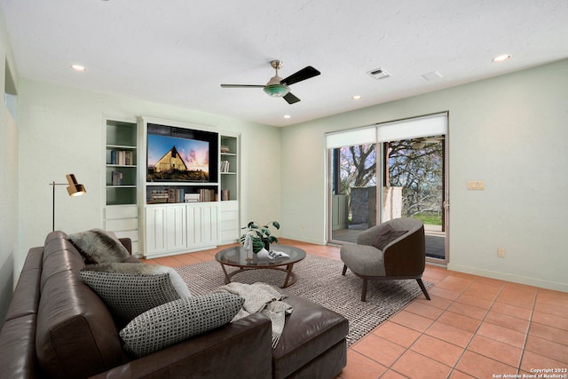 living room with built in shelves, light tile patterned floors, and ceiling fan