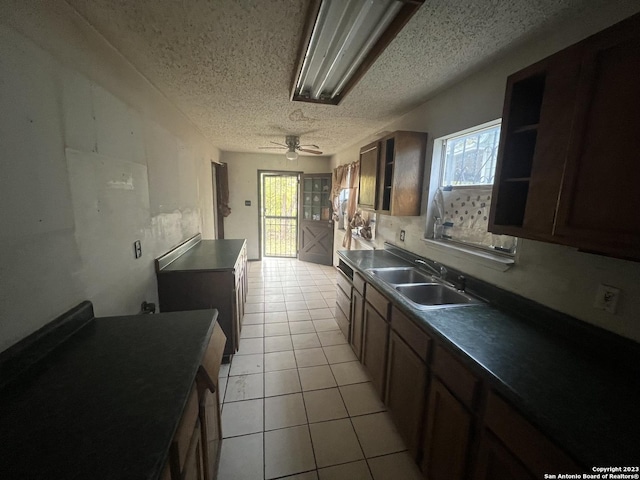 kitchen with ceiling fan, sink, a textured ceiling, and light tile patterned flooring