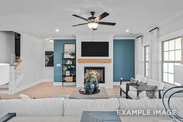 living room with ceiling fan, light hardwood / wood-style flooring, a fireplace, and ornamental molding