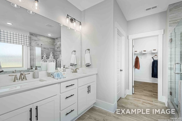 bathroom featuring hardwood / wood-style flooring, vanity, and a shower with shower door