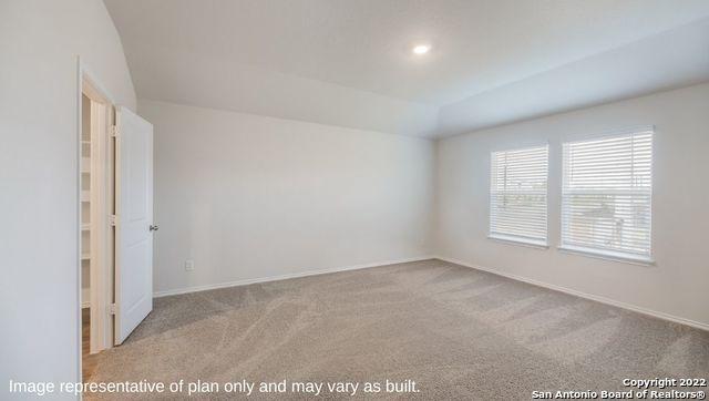 unfurnished room featuring light carpet and vaulted ceiling