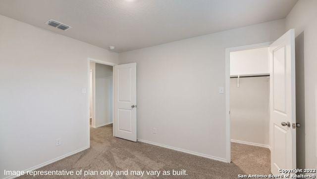 unfurnished bedroom with light carpet and a closet