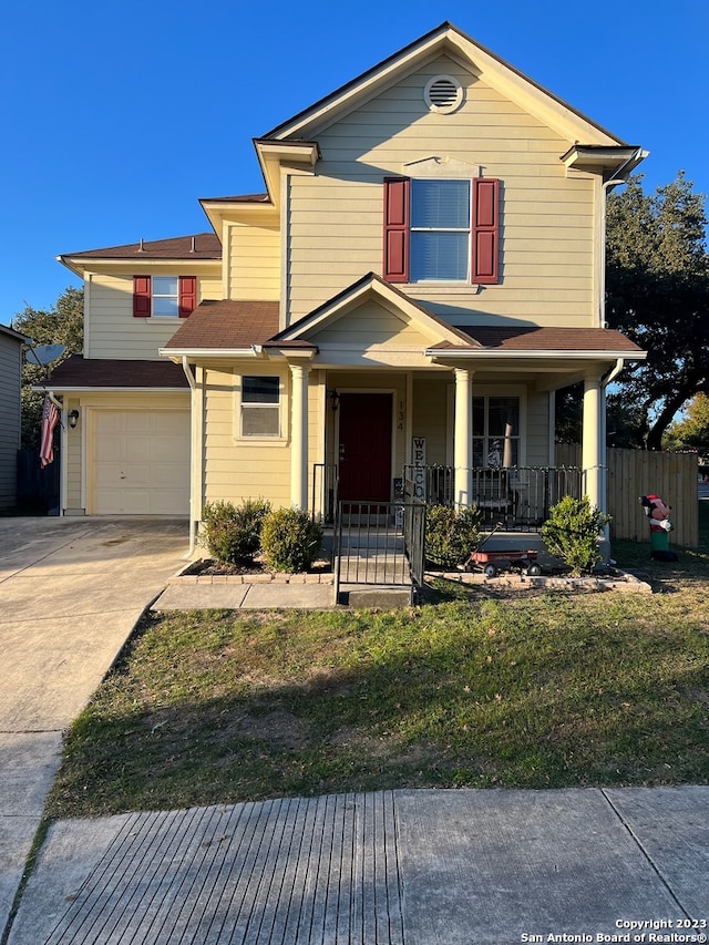 view of front of house with a front yard, a porch, and a garage