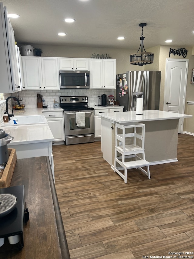 kitchen with pendant lighting, a center island, stainless steel appliances, and sink