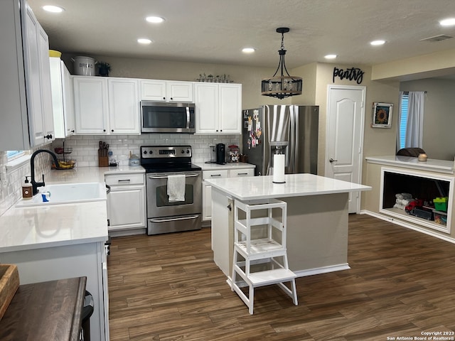 kitchen with stainless steel appliances, dark wood-type flooring, sink, pendant lighting, and a center island