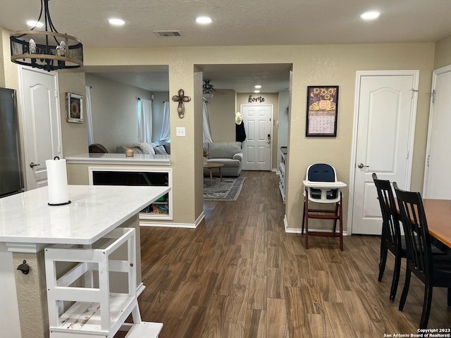 kitchen with dark hardwood / wood-style flooring, hanging light fixtures, and a textured ceiling