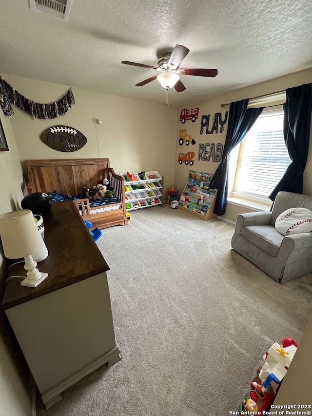 rec room featuring carpet flooring, ceiling fan, and a textured ceiling