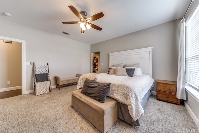 bedroom with light carpet, multiple windows, and ceiling fan