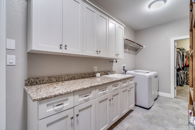 laundry room featuring cabinets, washer and clothes dryer, sink, and light tile patterned floors