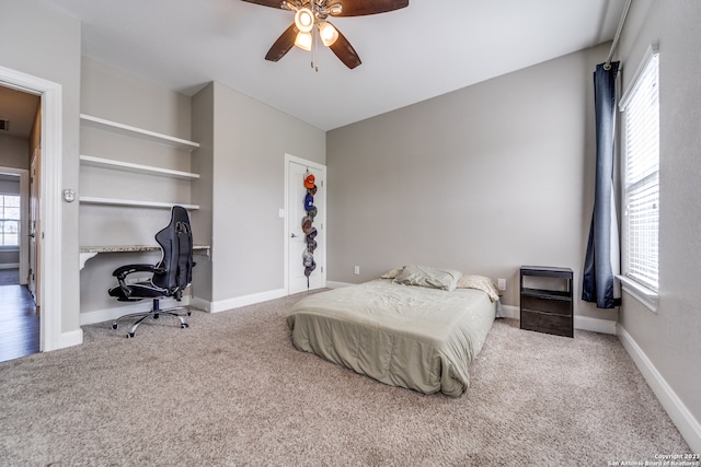 bedroom featuring light colored carpet, multiple windows, and ceiling fan