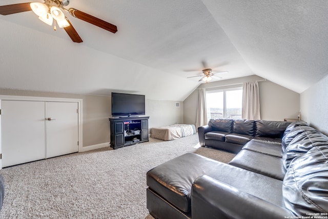 carpeted living room featuring a textured ceiling, ceiling fan, and lofted ceiling