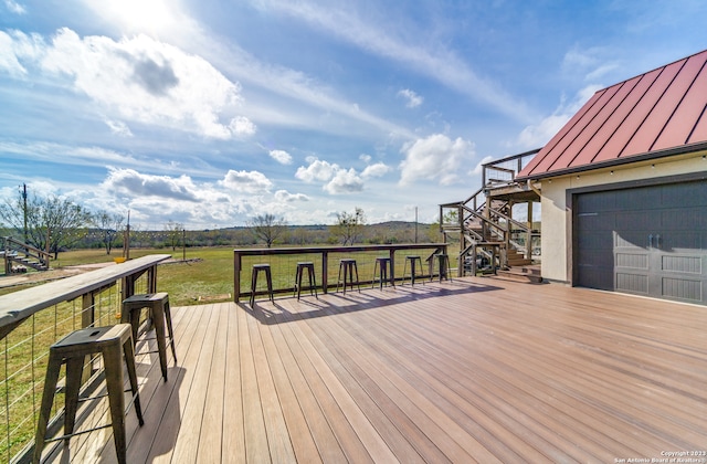 wooden terrace with a garage and a lawn