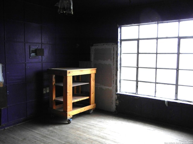 interior space featuring plenty of natural light, tile walls, and hardwood / wood-style flooring