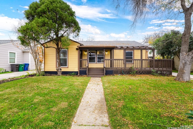 ranch-style house with a wooden deck and a front lawn