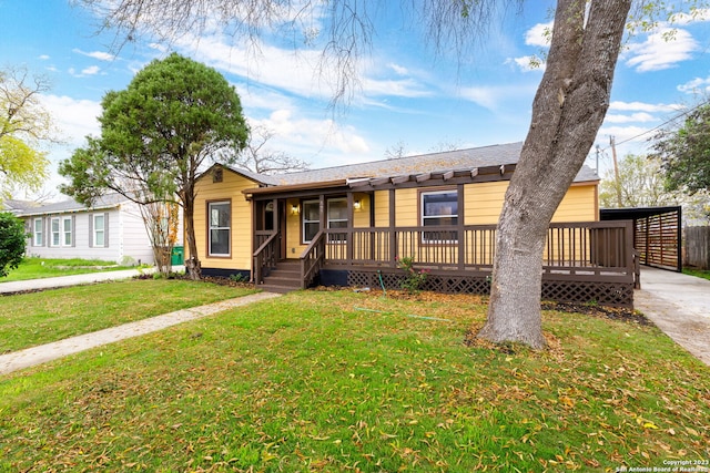 view of front facade with a deck and a front yard