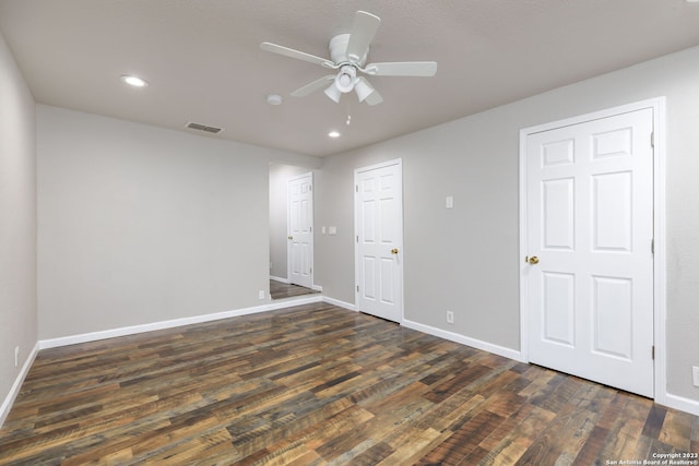 empty room featuring ceiling fan and dark wood-type flooring