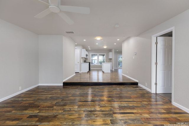 unfurnished living room with dark hardwood / wood-style floors and ceiling fan