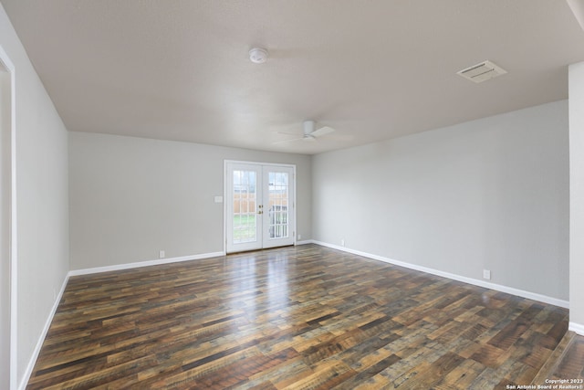 empty room featuring french doors, ceiling fan, and dark wood-type flooring