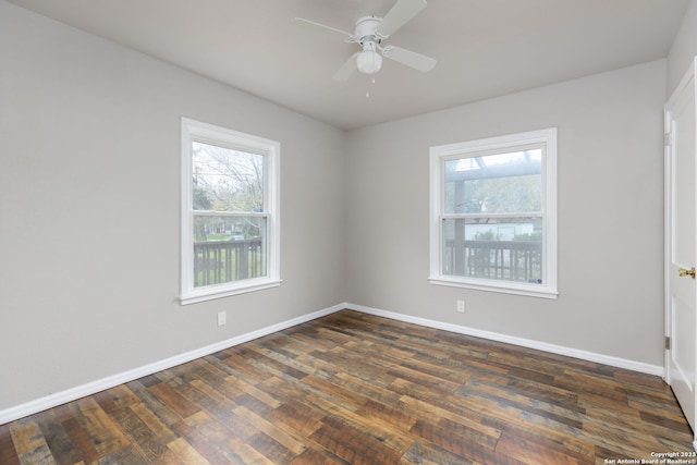 spare room with a wealth of natural light, ceiling fan, and dark wood-type flooring