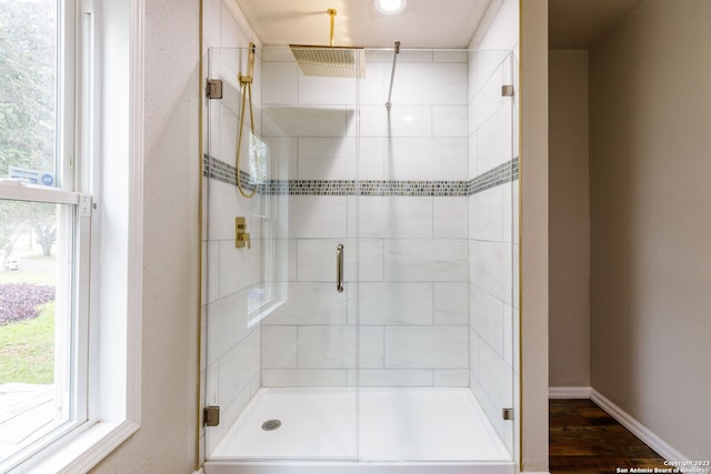 bathroom featuring walk in shower, hardwood / wood-style flooring, and plenty of natural light