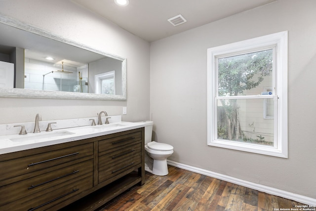 bathroom with hardwood / wood-style flooring, vanity, toilet, and an enclosed shower