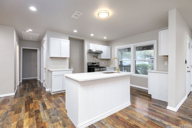 kitchen with gas stove, dark wood-type flooring, white cabinets, and an island with sink