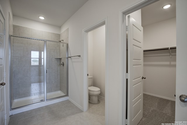 bathroom with toilet and a shower with door