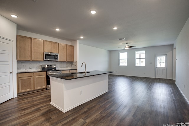 kitchen with an island with sink, stainless steel appliances, dark wood-type flooring, and sink