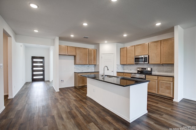 kitchen with a center island with sink, dark hardwood / wood-style floors, sink, and appliances with stainless steel finishes