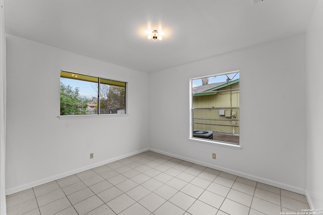 tiled spare room featuring a healthy amount of sunlight