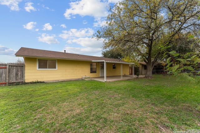 rear view of property featuring a lawn and a patio