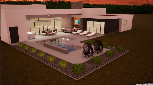 back house at dusk featuring outdoor lounge area and a patio