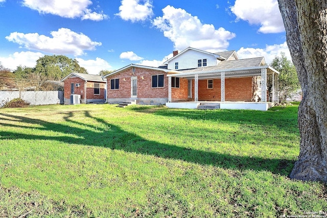 back of property with cooling unit and a yard