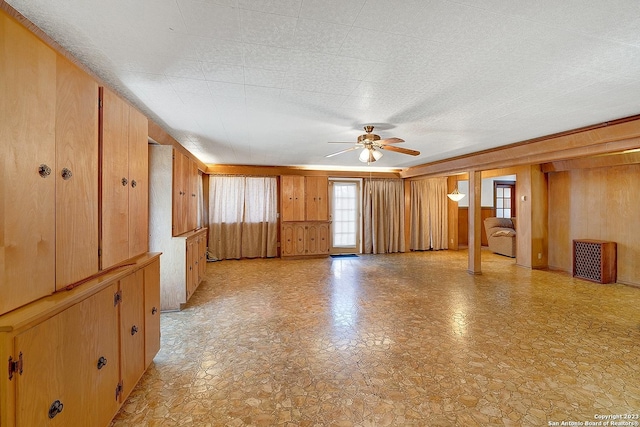 spare room featuring ceiling fan and wood walls