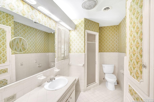 bathroom featuring tile walls, vanity, tile patterned floors, toilet, and walk in shower