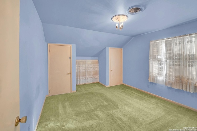 bonus room with vaulted ceiling and light carpet