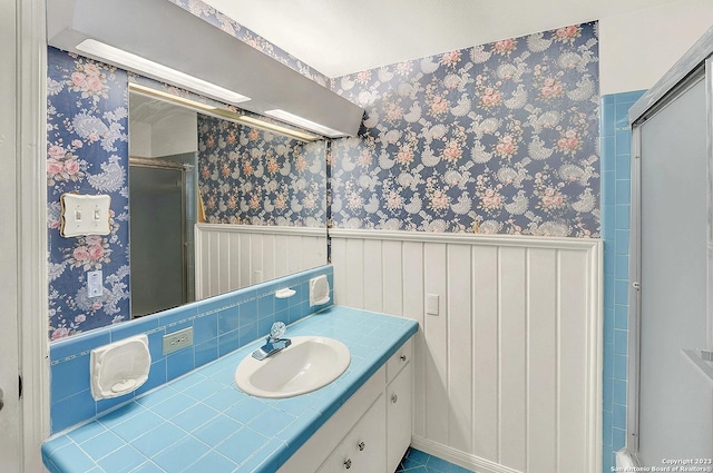 bathroom with vanity and a shower with door