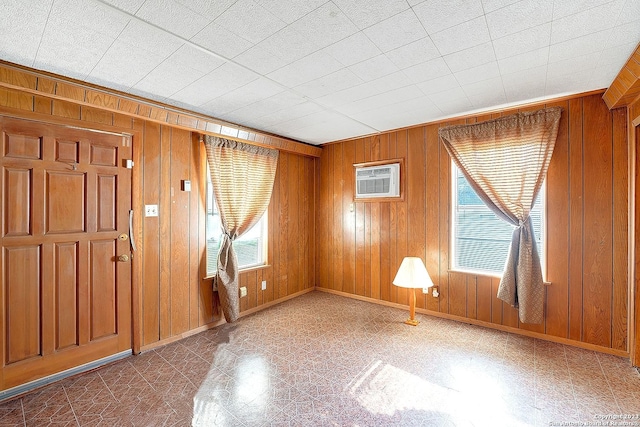 interior space with a wall mounted air conditioner and wood walls