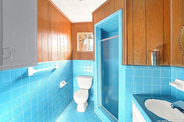 bathroom with sink, tile walls, tile patterned flooring, toilet, and a shower with door