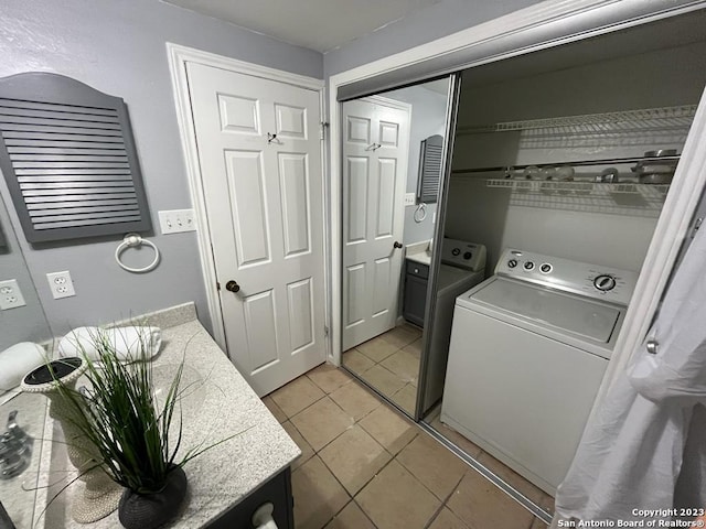 clothes washing area with light tile patterned flooring and independent washer and dryer