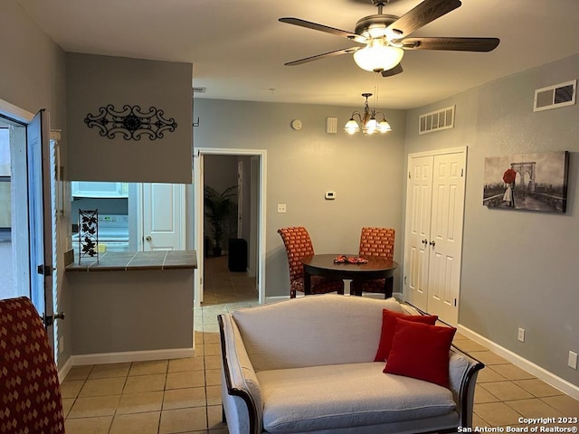 dining area featuring ceiling fan with notable chandelier and light tile patterned floors