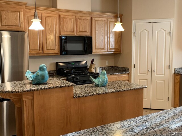 kitchen with stone countertops, light tile patterned floors, black appliances, and decorative light fixtures