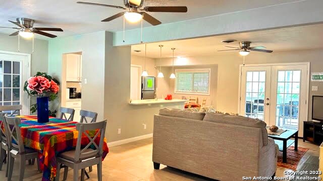 living room featuring french doors and ceiling fan