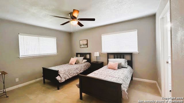 bedroom with multiple windows and ceiling fan