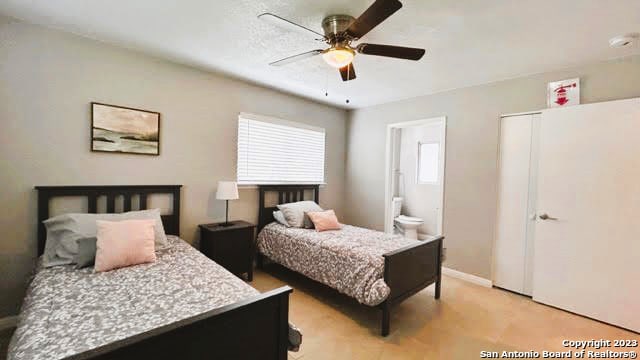 bedroom with ensuite bathroom and ceiling fan