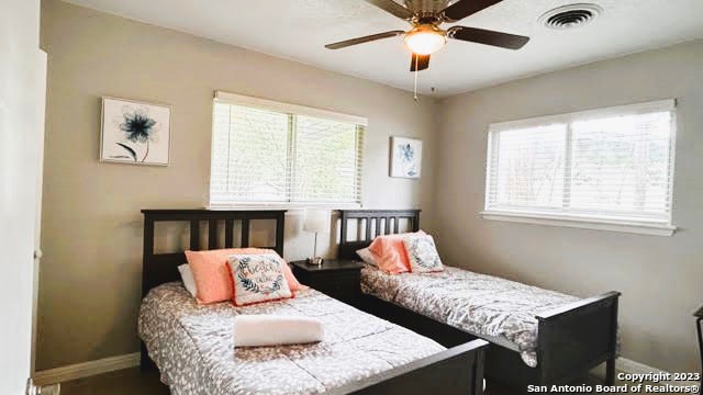 bedroom featuring multiple windows and ceiling fan