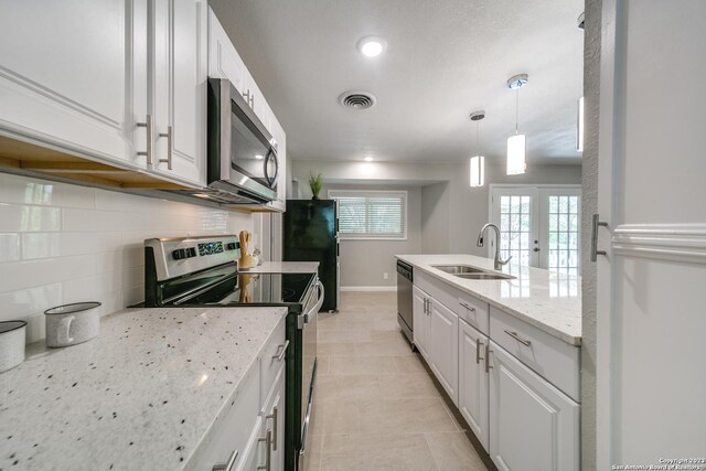 kitchen featuring sink, white cabinetry, light tile patterned floors, and stainless steel appliances